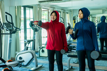 Muslim sport, Happy cheerful Asian Muslim mother and daughter Wearing Hijab and Sportswear smiling...