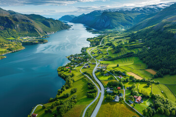 Aerial view of the beautiful Norwegian fjord surrounded by green mountains and fields, blue water flowing into it. - Powered by Adobe