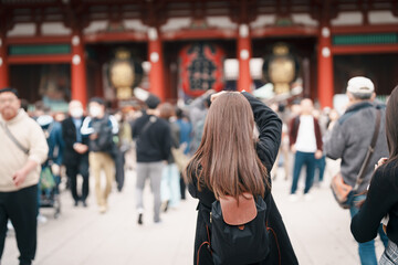 Tourist woman visit Sensoji Temple or Asakusa Kannon Temple is a Buddhist temple located in Asakusa, Tokyo Japan. Japanese sentence on red lantern means Thunder gate.