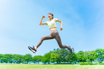 自然の中で元気よくジャンプする笑顔の女性