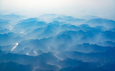 aerial view of mountain range in fog - Powered by Adobe