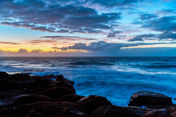 Sunrise, sea, waves, clouds and tessellated rock platform