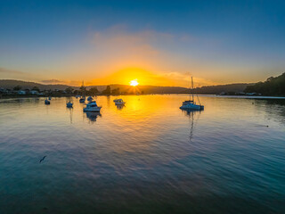 A fresh new day - sunrise waterscape with boats in the channel