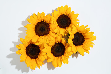 Some sunflowers arranged into a bouquet displayed in the middle of white table. High angle shot...
