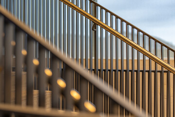 Close-up photo of a modern gray metal railing and concrete stair case between floors. 
 - Powered by Adobe