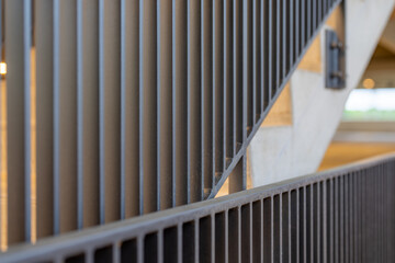 Close-up photo of a modern gray metal railing and concrete stair case between floors. 
