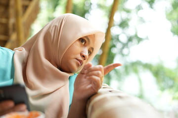 A hijab woman nsitting at the cafe