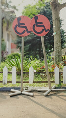 Low angle view of car parking sign posts intended for disabled people near the public garden. The implementing concept of human rights equality