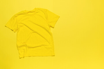 A simple yellow T-shirt on a yellow background.