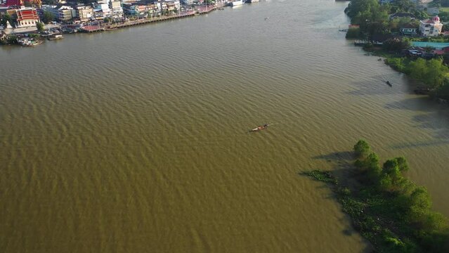 Drone orbiting a small fishing boat in front of the Surat Thani city, Thailand