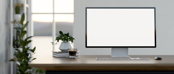 A computer desk in a minimal white room features a white-screen computer mockup on the desk.