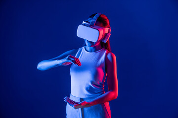 Female standing surrounded by neon light wear VR headset connecting metaverse, futuristic cyberspace community technology. Elegant woman using both hand interacting with virtual object. Hallucination.