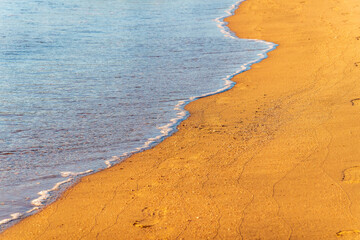 Soft wave of the sea on the sandy beach.