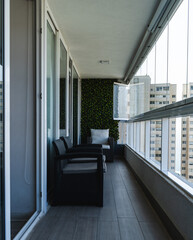 balcony with two wooden chairs, and a white chair at the background, looking outside. The balcony...