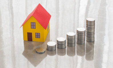 image with coins and miniature house representing an increase in house prices. increase in house...