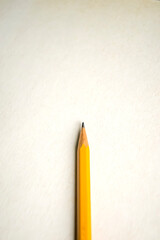 Amber pencil rests on white surface, office instrument made of wood and graphite