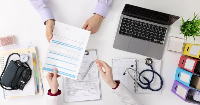 Doctor and patient discuss medical form sign documents for treatment, healthcare and medical concept