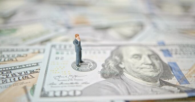 Businessman stands on USD note over fed logo depicting currency exchange of global trade forex. Fed increase interest rate to fight inflation and remain higher for longer with quantitative tightening.