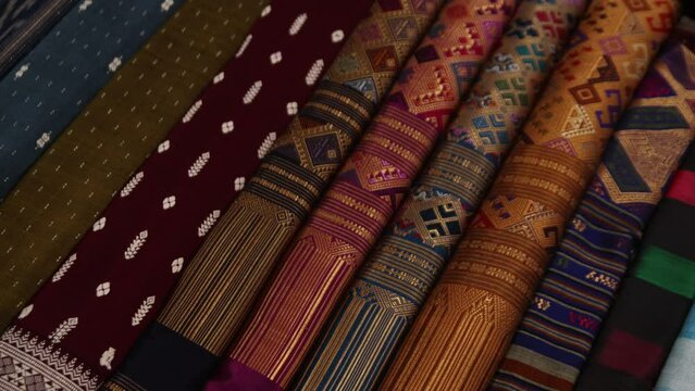 colorful traditional fabrics for sale at night market in Luang Prabang, Laos traveling Southeast Asia