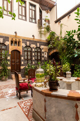 Interior of luxury hotel in oriental style with living plants and fountain in the lobby