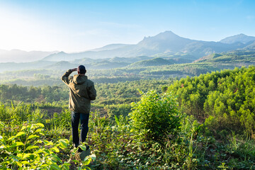 A hiker is looking at a tranquil, during sunrise in a mountainous wilderness Da Lat Vietnam