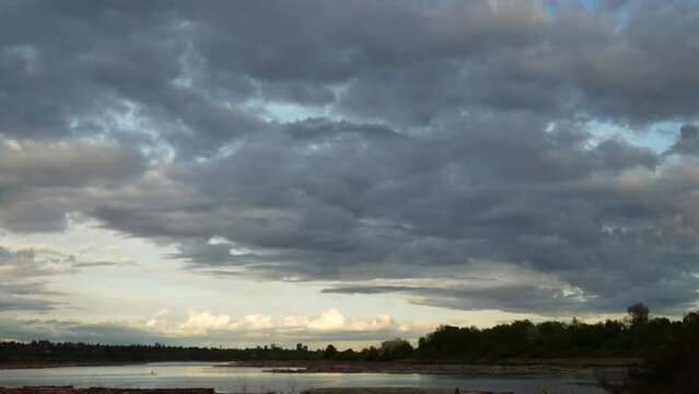 Serene River Landscape Under a Dramatic Cloudy Sky at Dusk
