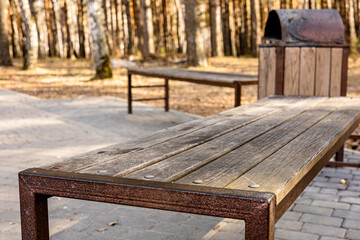 Wooden park furniture, wooden benches and wooden waste container in a public park. Long-lasting...