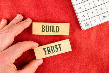Build trust symbol text is made up of wooden blocks on a red background