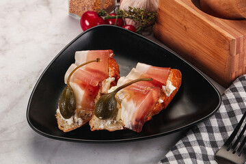 Bruschetta with jamon and caper berries