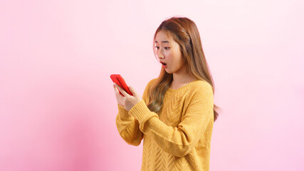Young woman excited face while surfing social media on smartphone isolated on pink background