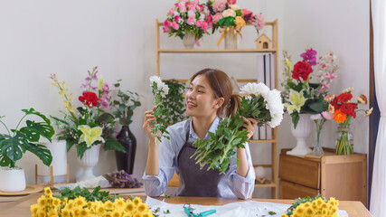Floristry concept, Woman florist choosing white chrysanthemum to making bouquet in flower shop