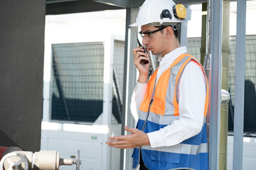 Asia Man engineer using walkie talkie working at rooftop building construction or working checking...
