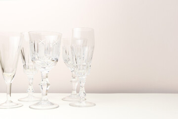 Empty crystal glasses in front of beige background. Place for text.