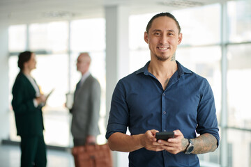 Portrait of smiling successful businessman using mobile app