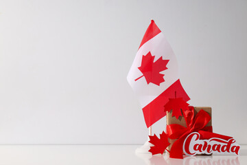 Canadian flag with a gift on a light background