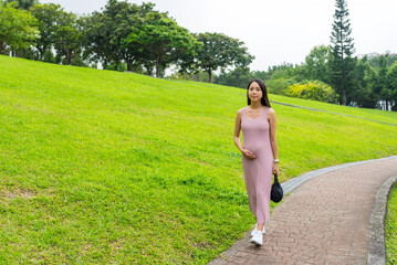 Asian Pregnant woman walk along the park