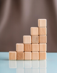 Wooden blocks arranged incrementally on a smooth surface, concept of growth