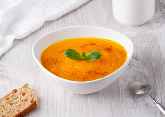 Pumpkin soup on a white wooden table