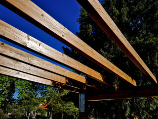 wooden construction of the bus stop, shelter of a gazebo pergola. the roof and walls are lined with...
