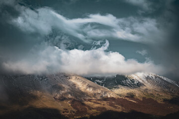 clouds over the mountains covered in snow