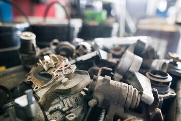 Metal components on workbench in auto repair shop. Mechanics repairing, maintaining car in garage,