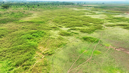 Aerial view, A parched landscape stretches beyond a dam with receded water levels. Cracked earth...