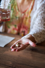 A close up of a hand of senior woman with pills.