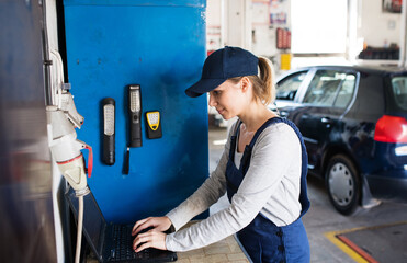 Female auto typing on laptop, ordering parts, communicating with customer. Beautiful woman working...