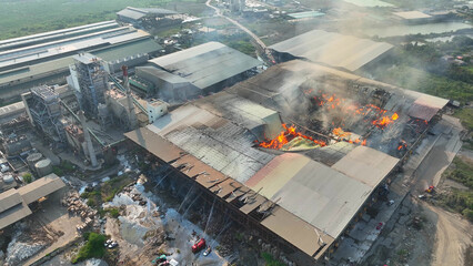Inferno consumes the industrial giant, its steel skeleton now a mere frame amidst raging flames....