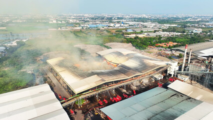 Aerial perspective reveals a frenzied firefighting operation at an industrial site....