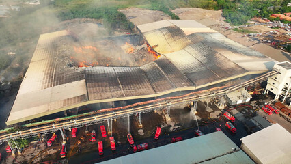 An expansive aerial perspective captures the relentless blaze consuming the industrial site....