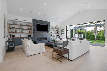 Living room with big screen TV and patio view in a modern new construction home in Los Angeles