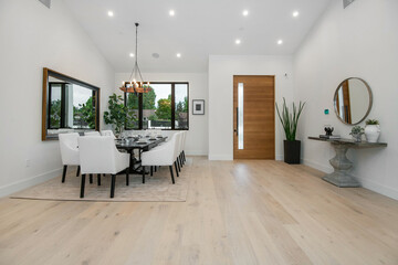 Dining area with a lengthy table in a modern new construction home in Los Angeles