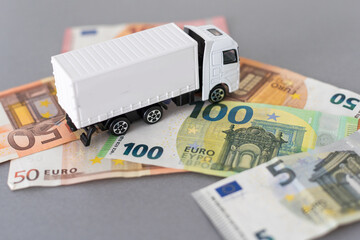 White toy truck lie on dollars, space for text.